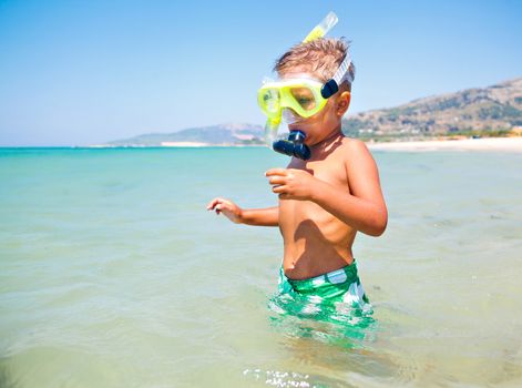 Summer vacation - Portrait of happy boy in face masks and snorkels, sea in background.