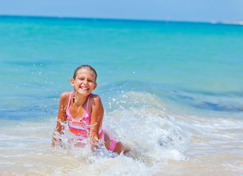 Summer vacation - Happy cute girl having fun with surfboard in the ocean