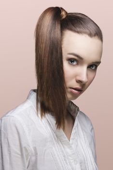 close-up portrait of pretty young girl with brown hair, ponytail on the right and white shirt