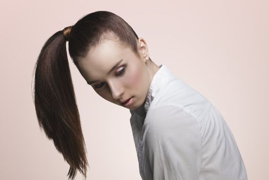 sensual young girl with brown ponytail hairstyle on the right, pretty make-up wearing white shirt