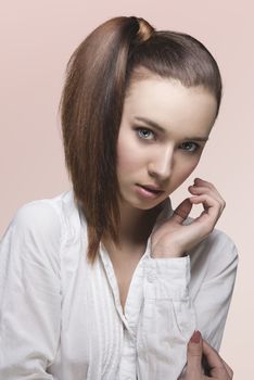 pretty girl posing with smooth ponytail hair-style on the right, white shirt and looking in camera