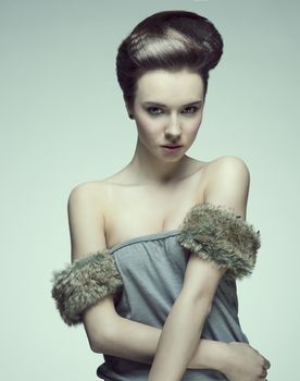 sexy and beautiful young girl with creative hair style and fur in arm looking camera strongly