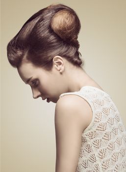 pretty brunette girl posing in profile with fashion creative hair-style, cute make-up and elegant sweater
