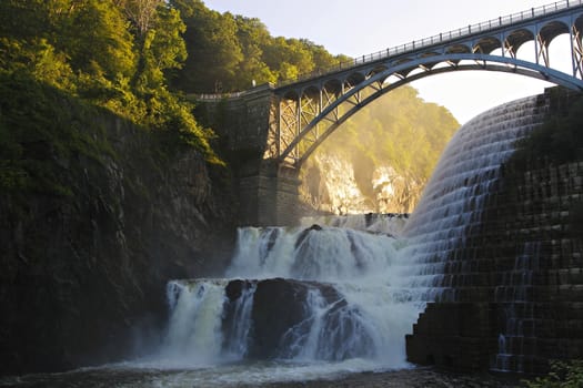 Dam on mountain river. Expanded water from the waterfall.