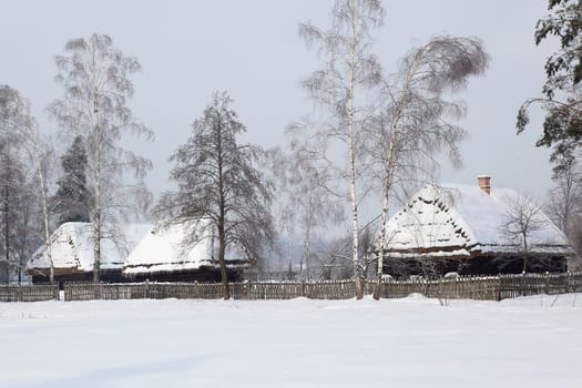 Old hauses with snow on the roof. Museum in kolbuszowa, Poland