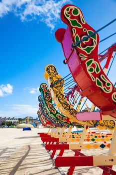 Brightly coloured retro swing boats on the beach in the UK