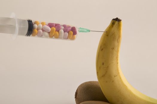 Male impotence metaphor: banana,kiwi and syringe with pills