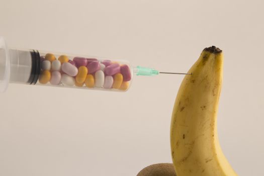 Male impotence metaphor: banana,kiwi and syringe with pills