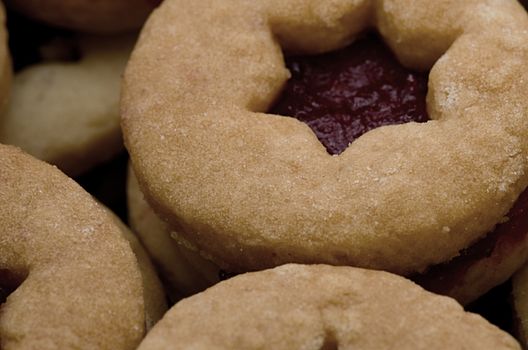 Round cookies with red jam in star-shaped hole 