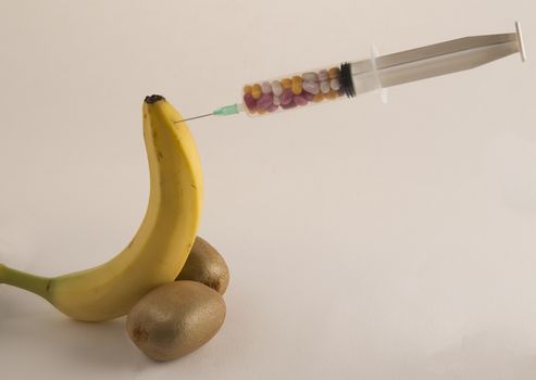 Male impotence metaphor: banana,kiwi and syringe with pills