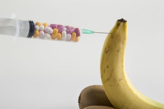 Male impotence metaphor: banana,kiwi and syringe with pills