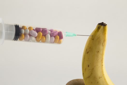 Male impotence metaphor: banana,kiwi and syringe with pills