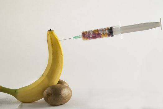 Male impotence metaphor: banana,kiwi and syringe with pills