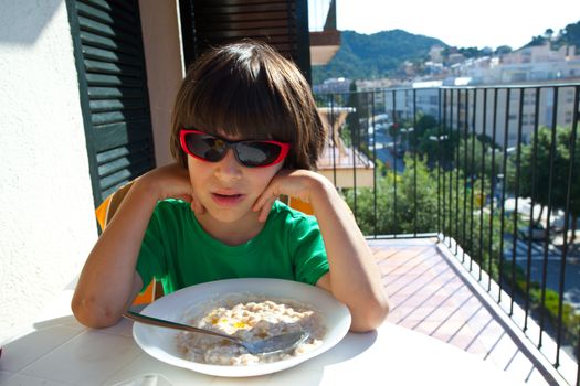 breakfast of boy in green t-shirt on the open air