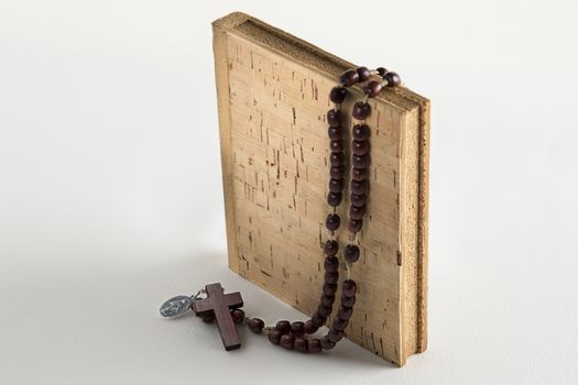 Holy Rosary beads necklace on cork book