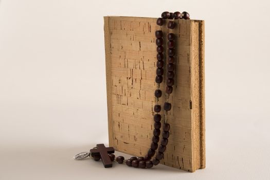 Holy Rosary beads necklace on cork book