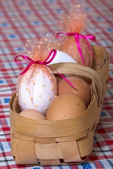 Easter eggs in the basket on the tablecloth