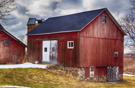 Large red bank barn. New Roof. Crisp colors and overcast sky. 