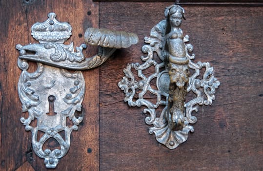 Door-handle decoration detail of old metal iron entrance door in Prague