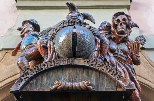 Marquee sign for a Marionette Theatre in Prague features several phantasmagoria creatures including Death and a Jester.