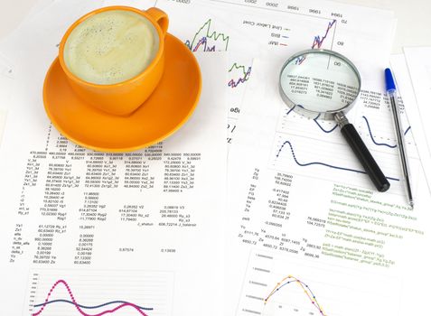 Cup of coffee, business objects and paper with graphs. Business concept