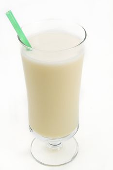 Vanilla milkshake with a green straw against a white background