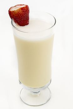 Vanilla milkshake with a strawberry on the side against a white background