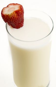 Vanilla milkshake with a strawberry on the side against a white background