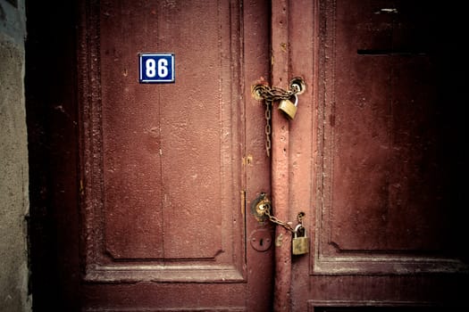 Old rusty padlock and chain on the wooden gate home
