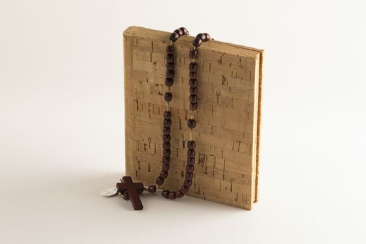 Holy Rosary beads necklace on cork book