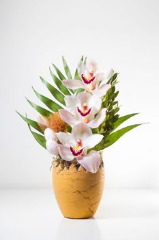 Easter vase with flowers and Easter eggs on white