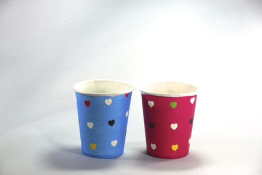 two colourful paper cups on white scene,shallow focus