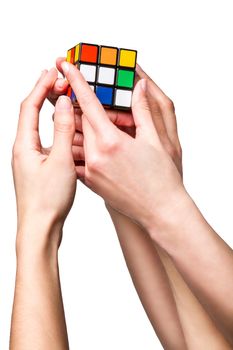 Hands holding color cube on white background
