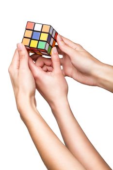 Hands holding color cube on white background
