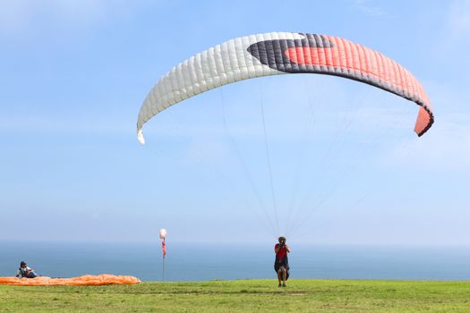 LIMA, PERU - FEBRUARY 20, 2012: Unidentified person with a paraglider on the coast of Miraflores on February 20, 2012 in Lima, Peru. Paragliding is a popular sport on the coast of Miraflores, where winds are usually good and in good weather a big part of the coast of Lima can be seen. 