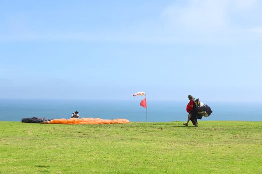 LIMA, PERU - FEBRUARY 20, 2012: Unidentified people with paragliders on the coast of Miraflores on February 20, 2012 in Lima, Peru. Paragliding is a popular sport on the coast of Miraflores, where winds are usually good and in good weather a big part of the coast of Lima can be seen. 