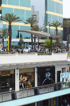 LIMA, PERU - JULY 23, 2013: Unidentified people at the shopping mall Larcomar built on the steep coast of Miraflores with the JW Marriott Hotel Lima in the back on July 23, 2013 in Lima, Peru. Larcomar is an upscale and modern shopping mall which people not only visit to shop but also for the view over the coast of Miraflores, as well as for dining and partying. 
