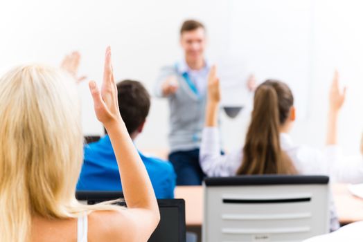 image of a female hand raised in university classroom