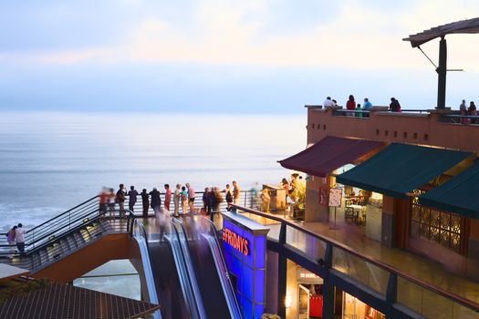LIMA, PERU - MARCH 11, 2012: Unidentified people in the shopping mall Larcomar in the evening on March 11, 2012 in Miraflores, Lima, Peru. Larcomar is a popular mall on the coast with a view over the coast of Lima. 