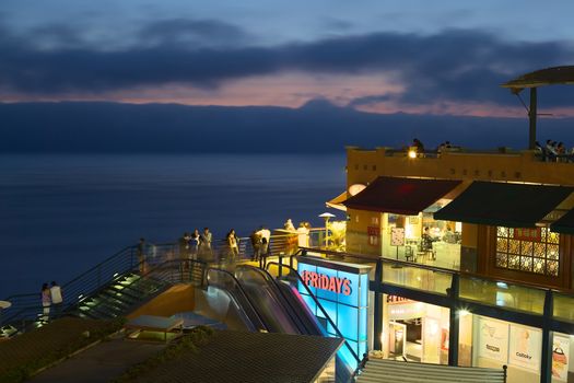 LIMA, PERU - MARCH 11, 2012: Unidentified people in the shopping mall Larcomar in the evening on March 11, 2012 in Miraflores, Lima, Peru. Larcomar is a popular mall on the coast with a view over the coast of Lima. 