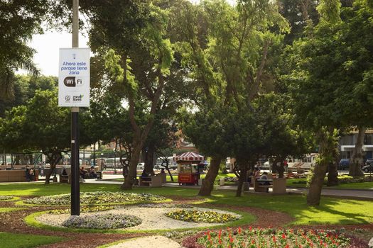 LIMA, PERU - DECEMBER 13, 2011: Wifi-Zone sign with unidentified people in the back in the Kennedy Park in the district of Miraflores on December 13, 2011 in Lima, Peru. Miraflores is one of the most modern districts of Lima, where the municipality invests in the improvement of public spaces.
