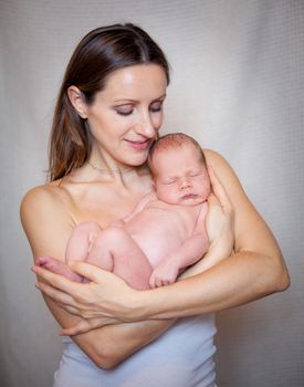 Mother holding tenderly a newborn baby boy, 11 day old