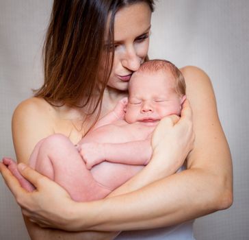 Mother holding tenderly a newborn baby boy, 11 day old