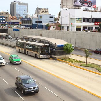 LIMA, PERU - FEBRUARY 13, 2012: Metropolitano bus of the Line B stopping at the crossing of the Avenues Ricardo Palma and Paseo de la Republica in Miraflores on February 13, 2012 in Lima, Peru. The Metropolitano is a Bus rapid transit system operating since 2010 in Lima running from North to South.
