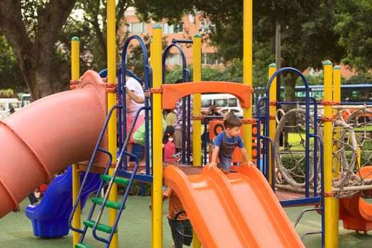 LIMA, PERU - MARCH 5, 2012: Unidentified children on a slide on the playground at Kennedy Park in Miraflores on March 5, 2012 in Lima, Peru. The municipality of Miraflores invests a lot into improving its public spaces.