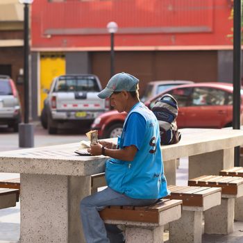 LIMA, PERU - MARCH 5, 2012: Unidentified street money exchanger counting dollar bills at an outdoor table in Miraflores on March 5, 2012 in Lima, Peru. Mobile money exchangers on the streets are very common in Lima.