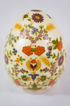 Easter egg decorated with flowers made by decoupage technique on light background