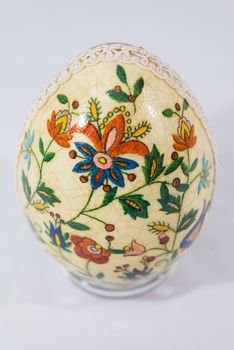 Easter egg decorated with flowers made by decoupage technique on light background