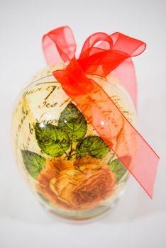 Easter egg decorated with flowers made by decoupage technique on light background