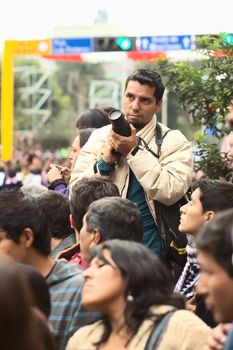 LIMA, PERU - JULY 21, 2013: Unidentified young man with a dslr camera on the Wong Parade in Miraflores on July 21, 2013 in Lima, Peru. The Parade (Gran Corso de Wong) is a traditional parade to celebrate the Peruvian national holiday which is on July 28-29.